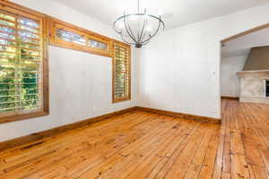 Spare room with an inviting chandelier and light hardwood / wood-style flooring