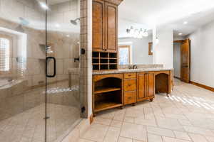 Bathroom with oversized vanity, tile floors, and an enclosed shower