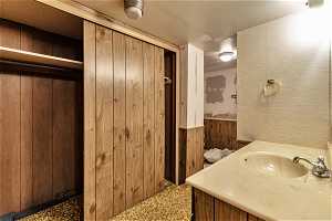 Bathroom with vanity and wooden walls