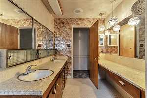 Bathroom with backsplash, oversized vanity, tile floors, and dual sinks