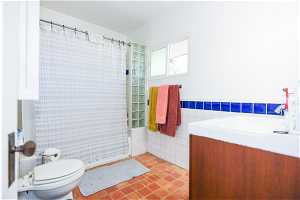 Bathroom featuring tile flooring, tile walls, vanity, and toilet