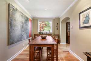 Dining area featuring crown molding and light hardwood / wood-style flooring