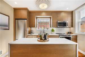 Kitchen featuring appliances with stainless steel finishes, light hardwood / wood-style flooring, and a kitchen island