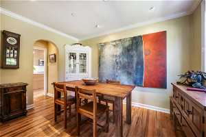 Dining room with crown molding and wood-type flooring