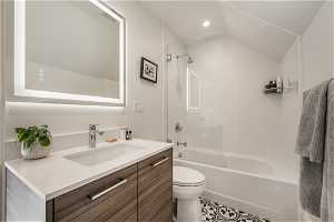 Full bathroom with vanity with extensive cabinet space, shower / washtub combination, toilet, and tile flooring