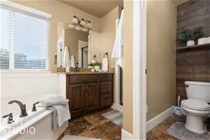 Full bathroom with tile flooring, independent shower and bath, vanity, and toilet