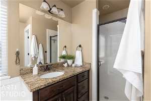 Bathroom with a shower with door and vanity with extensive cabinet space