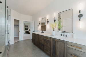 Ensuite bathroom with double vanity, a stall shower, and tile patterned flooring