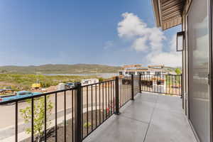Balcony featuring a water and mountain view