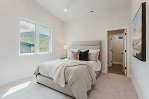 Carpeted bedroom with baseboards and vaulted ceiling