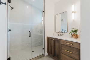 Full bathroom featuring vanity, a shower stall, and tile patterned flooring