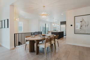 Dining area with a chandelier, recessed lighting, light wood-type flooring, and vaulted ceiling