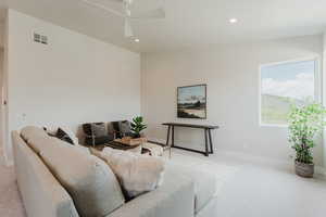 Living area with light colored carpet, recessed lighting, and a ceiling fan