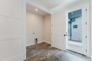 Washroom with electric dryer hookup, recessed lighting, and stone finish floors