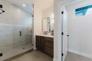 Full bathroom with vanity, a stall shower, and tile patterned floors