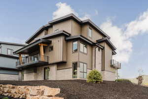 View of home's exterior with a balcony and stone siding