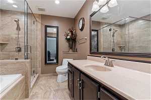 Full bathroom with vanity with extensive cabinet space, toilet, tile floors, and plus walk in shower