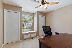 Home office featuring light colored carpet and ceiling fan