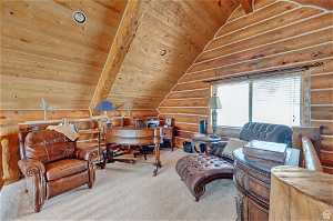 Interior space featuring wood ceiling, carpet, vaulted ceiling, and log walls