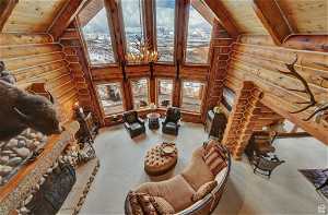 Carpeted living room with log walls, high vaulted ceiling, wooden ceiling, and beam ceiling