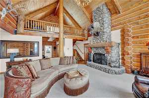 Living room with carpet, high vaulted ceiling, a fireplace, rustic walls, and wood ceiling