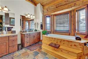 Bathroom with tile floors, a bathtub, vanity, and wooden ceiling