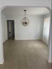 Unfurnished room featuring a chandelier and wood-type flooring