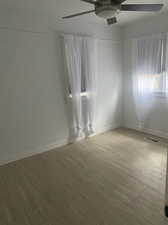 Empty room featuring hardwood / wood-style flooring and ceiling fan