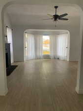 Interior space featuring wood-type flooring, ceiling fan, and a fireplace