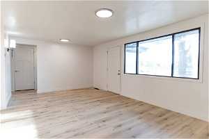Empty room with a healthy amount of sunlight and light hardwood (LVP)/ wood-style flooring