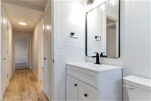 Bathroom with toilet, hardwood (LVP)/ wood-style floors, and large vanity