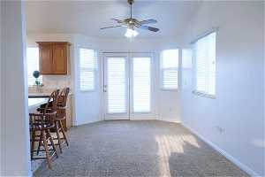 Kitchen featuring plenty of natural light, light colored carpet, and ceiling fan