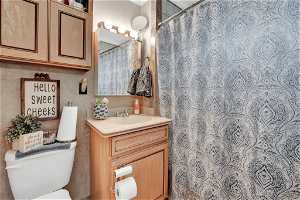 Bathroom with tile walls, toilet, and vanity