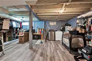 Basement with hardwood / wood-style flooring and washer and clothes dryer