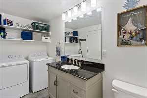 Bathroom with a sink, toilet , shower and washer dryer area