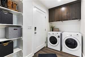 Laundry area with separate washer and dryer, cabinets, and dark hardwood / wood-style floors