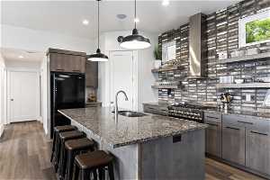 Kitchen featuring decorative light fixtures, granite countertops, dark wood-type flooring, and 36" dual fuel range.