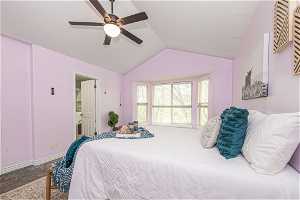 Bedroom featuring ensuite bath, ceiling fan, carpet floors, and lofted ceiling