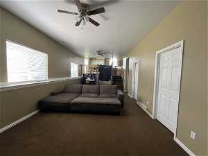 Basement Family room featuring multiple windows for extra sunlight, dark carpet, and ceiling fan