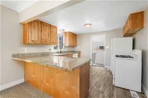 Kitchen featuring LVP flooring, kitchen peninsula, white appliances,  Granite counters,