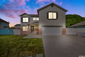 View of front facade with a garage and a lawn