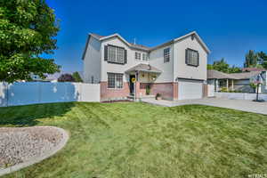 View of property with a garage and a front lawn