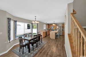 Dining space with a chandelier, dark wood-type flooring, and sink