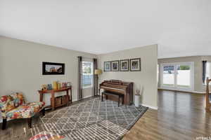 Living area with a healthy amount of sunlight and hardwood / wood-style floors