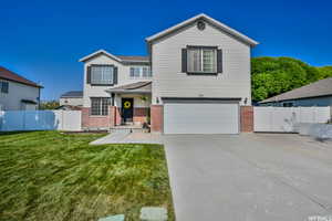 View of front of property featuring a garage and a front yard