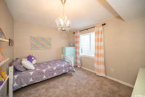 Bedroom with a chandelier and carpet floors