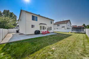 Back of house featuring a trampoline, a yard, and a patio area