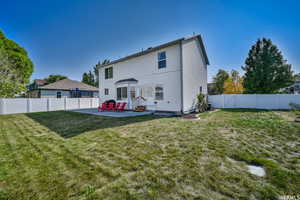 Rear view of property featuring a yard and a patio