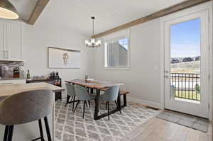 Dining room featuring a chandelier, light hardwood / wood-style floors, and beamed ceiling