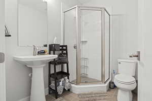 Bathroom with walk in shower, toilet, and tile floors